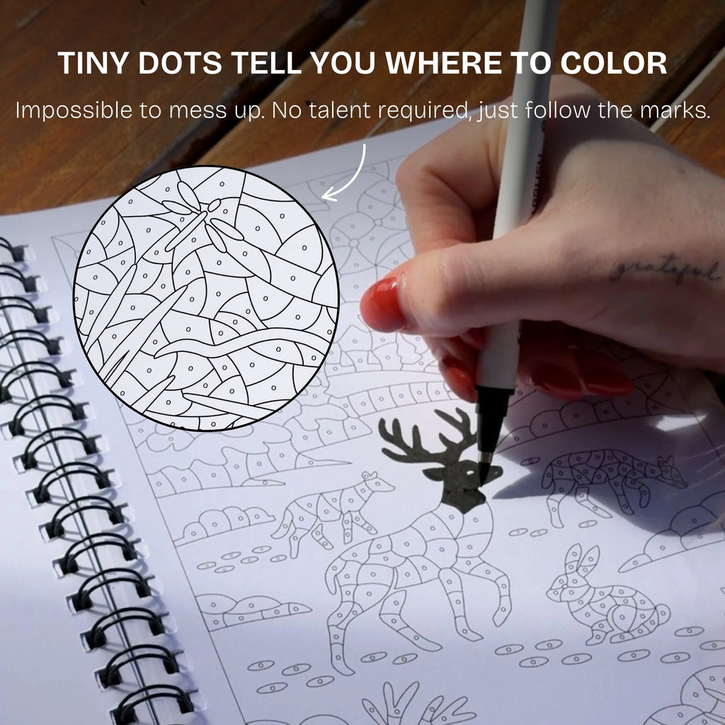 Hand colouring a deer illustration with a black pen, showing the tiny dots that mark where to colour