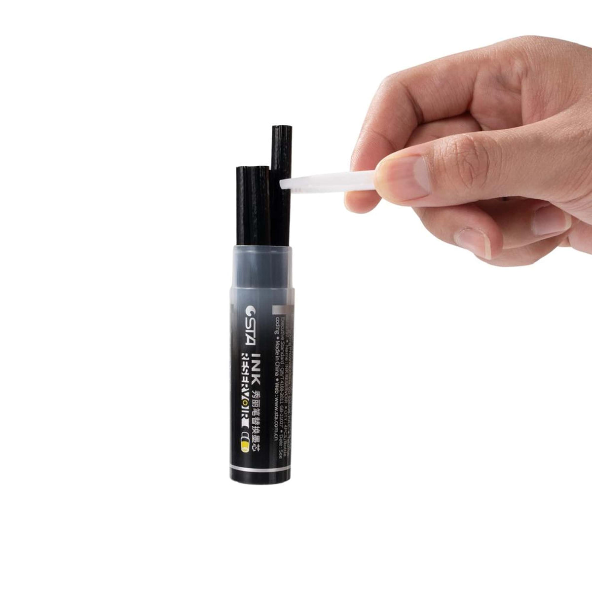 Hand pulling a white ink cartridge from the black refill tube Image