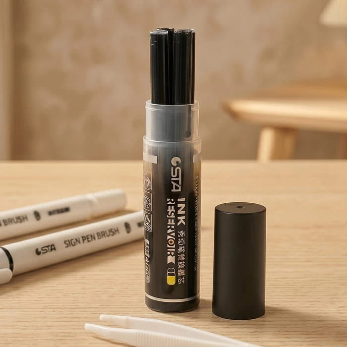 Open ink refill tube showing the black cartridges inside, on a table beside two brush pens